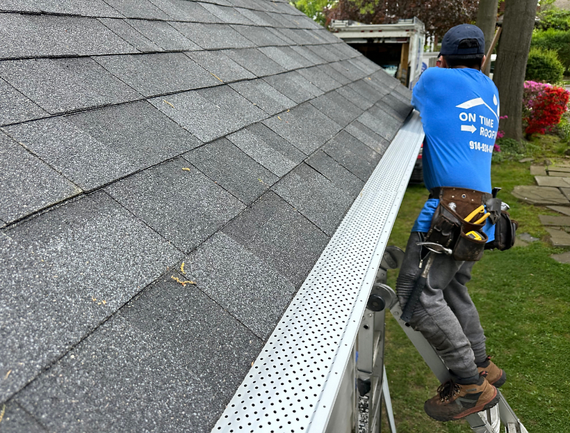 Residential roofing installation in New York, showcasing modern shingles and expert craftsmanship on a sunny day.