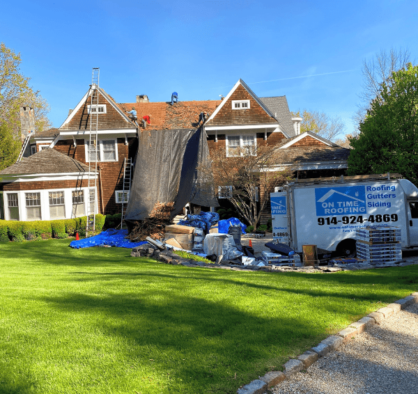 Residential roofing installation showcasing a newly constructed roof with shingles under clear blue sky.