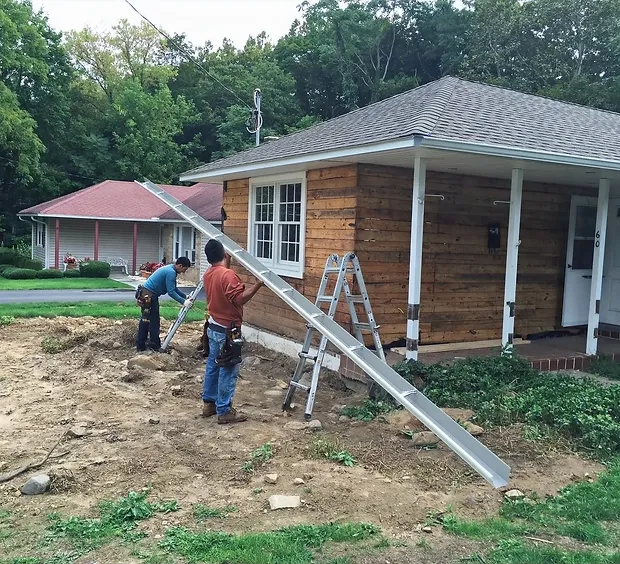 installing new gutter system in residential house roofing